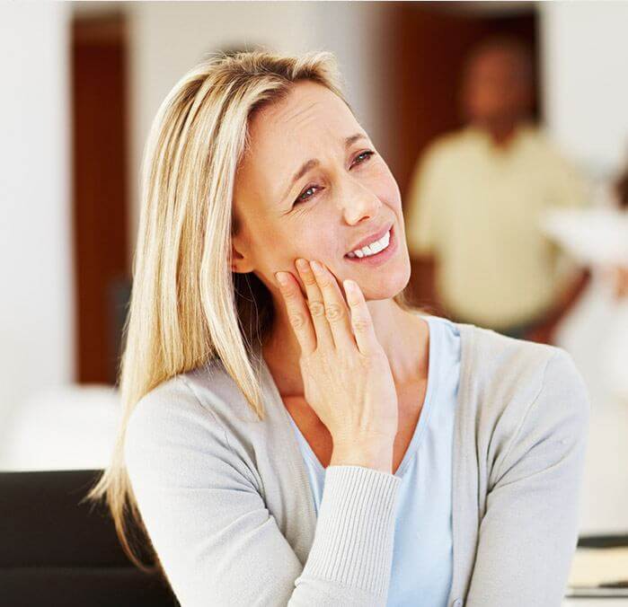 Woman holding cheek in pain